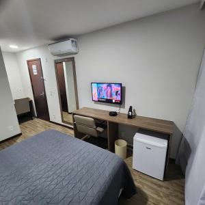 um quarto com uma cama e uma secretária com um computador em Suíte Premiere no Rio de Janeiro
