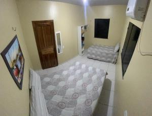 a small room with a bed and a television at Casa Boto Tucuxi 1 in Novo Airão