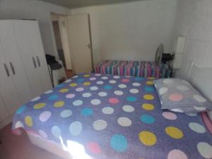 1 dormitorio con 1 cama con sábanas de lunares en Casa de Veraneio Laranjal, en Pelotas