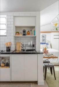 a kitchen with white cabinets and a counter top at STUDIO MONSIEUR 421 LEBLoN in Rio de Janeiro
