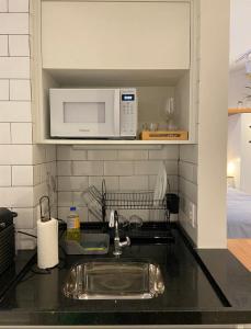 a kitchen counter with a sink and a microwave at STUDIO MONSIEUR 421 LEBLoN in Rio de Janeiro