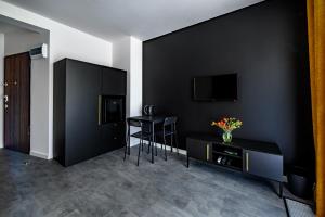 sala de estar con paredes negras, mesa y sillas en Apartament 5th floor, en Cracovia