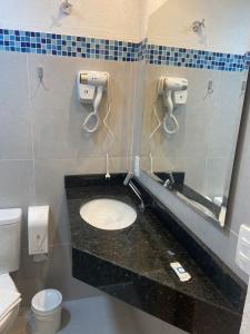 a bathroom with a sink and a mirror at Pousada Kainoa in Ilha do Mel