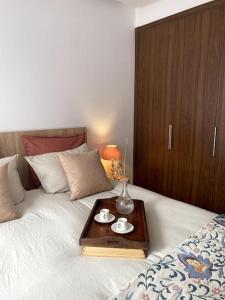 卡薩布蘭卡的住宿－Appartement Luxe - Casablanca，一张带盘子的床上,上面有两杯
