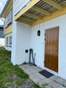 uma casa com uma porta de madeira e uma mangueira em Topview em Hammerfest