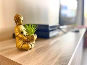 a small gold statue sitting on a table with a plant at *Le Royal*Havre De Paix*Wifi* in Marseille
