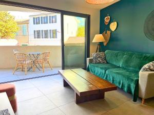 a living room with a green couch and a table at *Le Royal*Havre De Paix*Wifi* in Marseille