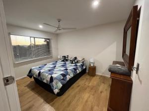 a bedroom with a bed with a blue and white blanket at CBR Equine Cottage in Amamoor