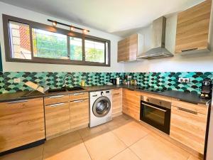 a kitchen with wooden cabinets and a washer and dryer at *Le Royal*Havre De Paix*Wifi* in Marseille