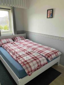 a bed in a bedroom with a plaid blanket at Topview in Hammerfest