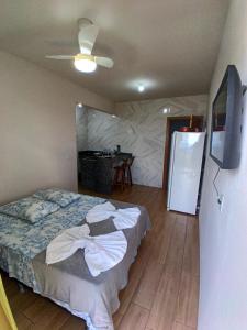 a bedroom with a bed and a ceiling fan at Flat 02 com Varanda - Avenida Hospedagem in São Thomé das Letras