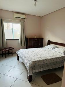 ein Schlafzimmer mit einem Bett und einem Fenster in der Unterkunft Portal do Mar-Casa 01 in Luis Correia