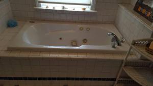 eine weiße Badewanne in einem Badezimmer mit Fenster in der Unterkunft Gloucester House with Sea View in Gloucester