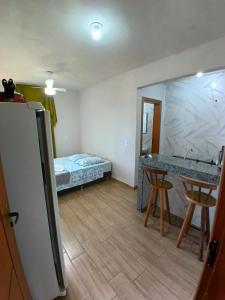 a room with a bed and a table and chairs at Flat 02 com Varanda - Avenida Hospedagem in São Thomé das Letras +2 photos