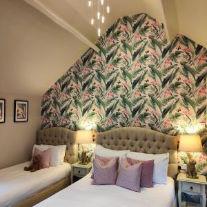 Duas camas num quarto com um mural de parede em The Corner House em Lowestoft