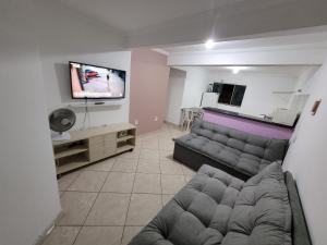 Il comprend un salon doté d'un canapé et d'une télévision à écran plat. dans l'établissement Apartamento 302 maravilhoso e espaçoso, à Brasilia