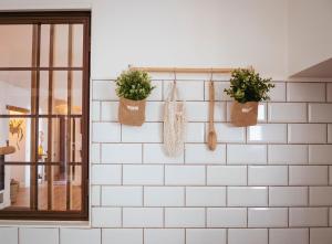 un mur de carrelage blanc avec des plantes en pot dans l'établissement Casa Taray, 