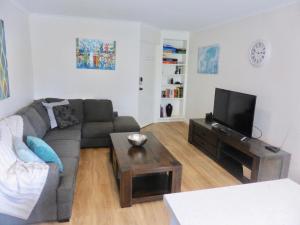 a living room with a couch and a tv at View Street Vista location parking and views in Sandy Bay