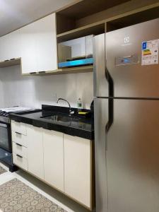 a kitchen with a stainless steel refrigerator and white cabinets at Cabo Frio - Temporadas in Cabo Frio