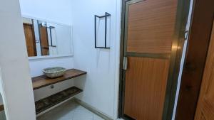 a bathroom with a wooden door and a mirror at BabaJay Family Home in Dar es Salaam