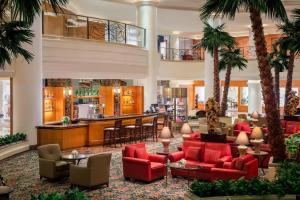een lobby met palmbomen en rode stoelen bij Shanghai Marriott Hotel Hongqiao in Shanghai