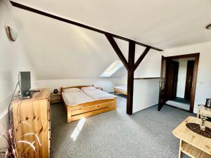 a bedroom with a bed and a desk in a attic at Pod Klíčem in Svor