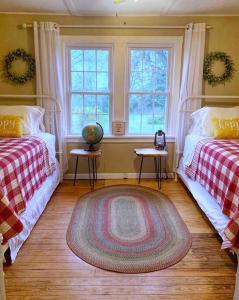 a bedroom with two beds and two windows at Green Acres Farmhouse Fugitive Beach/Military/MS&T in Rolla