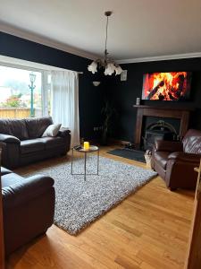 a living room with a couch and a fireplace at Malahide Guest Rooms in Malahide