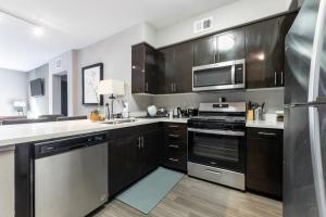 a kitchen with black cabinets and stainless steel appliances at Private, Modern Luxury 2 Bd/ 2 Ba in Santa Ana