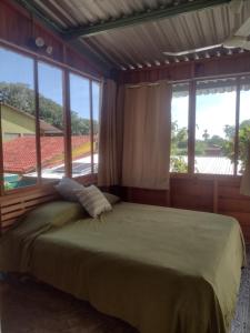 1 dormitorio con 1 cama y ventana grande en ORidleys Hostel16, en Barra de Potosí