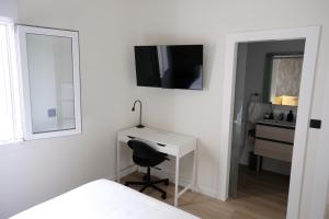 Habitación blanca con escritorio y espejo. en Urban Oasis La Palma, en Santa Cruz de la Palma
