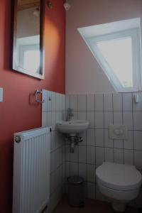 La salle de bains est pourvue de toilettes, d'un lavabo et d'une fenêtre. dans l'établissement Omas Linde, à Brandebourg-sur-la-Havel