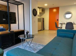 ein Wohnzimmer mit einem blauen Sofa und einem Tisch in der Unterkunft 512 Hermoso loft con balcón in Bogotá