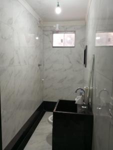a bathroom with a sink and a shower at Apartamento Flat in Anápolis
