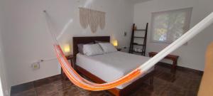 uma cama num quarto com rede de descanso em Casa Mahe, Chelem, Yucatán em Chelem