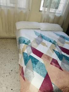 a bed with a colorful quilt on it in a room at Casa Tajín in Monterrey