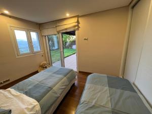 Habitación con 2 camas y puerta a una puerta en Luxueux VILLA avec jardin et vue panoramique, en Tetuán