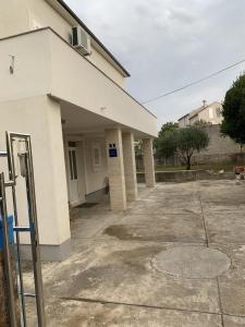 a large white building with a parking lot at Beach House Murter in Murter +8 photos