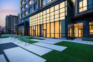 a building with tables and chairs in front of it at Courtyard by Marriott Shanghai Hongqiao in Qingpu