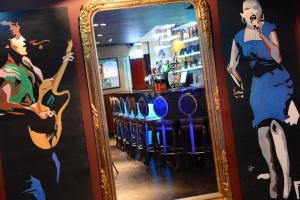 a mirror in a bar with a picture of a woman at Slaney Suites in Enniscorthy