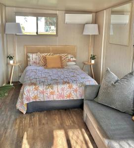 um quarto com uma cama e um sofá em Mornington Peninsula Retro Caravans em Rye