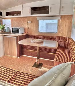 uma pequena cozinha com uma mesa num trailer em Mornington Peninsula Retro Caravans em Rye