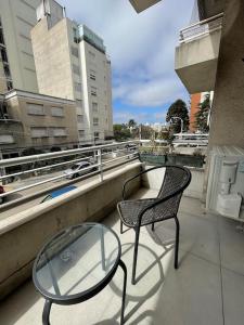 2 sedie e un tavolo in vetro sul balcone di Quaint, cozy apart in best location a Montevideo