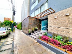 a building with stairs and flowers in front of it at Lima Gold Apartaments Family 4B203 in Lima