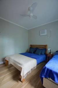 a bedroom with two beds with blue and white sheets at Estúdio com Ar Refrigerado a 300 m Praia in Cabo Frio