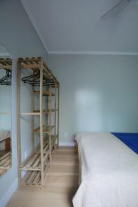 Habitación con cama y escalera junto a la pared en Estúdio com Ar Refrigerado a 300 m Praia, en Cabo Frío