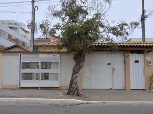 un bâtiment avec un arbre en face dans l'établissement Estúdio com Ar Refrigerado a 300 m Praia, à Cabo Frio