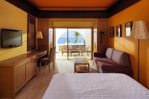 a hotel room with a bedroom with a bed and a television at Retac Qunay Dahab Resort & SPA in Dahab