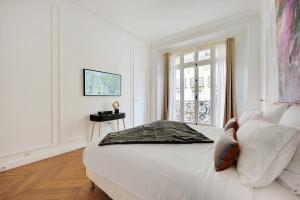 a white bedroom with a large bed and a window at Eiffel Tower 5 bedrooms 10 guests with 2 Carpark in Paris