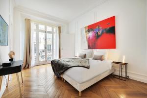 a bedroom with a bed and a large painting on the wall at Eiffel Tower 5 bedrooms 10 guests with 2 Carpark in Paris